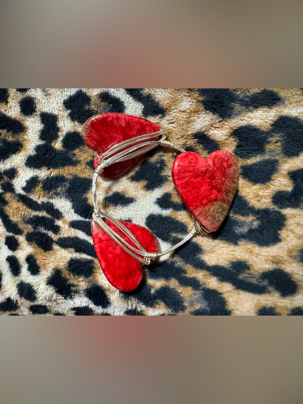 Wire-wrapped bangle bracelet featuring heart-shaped stones